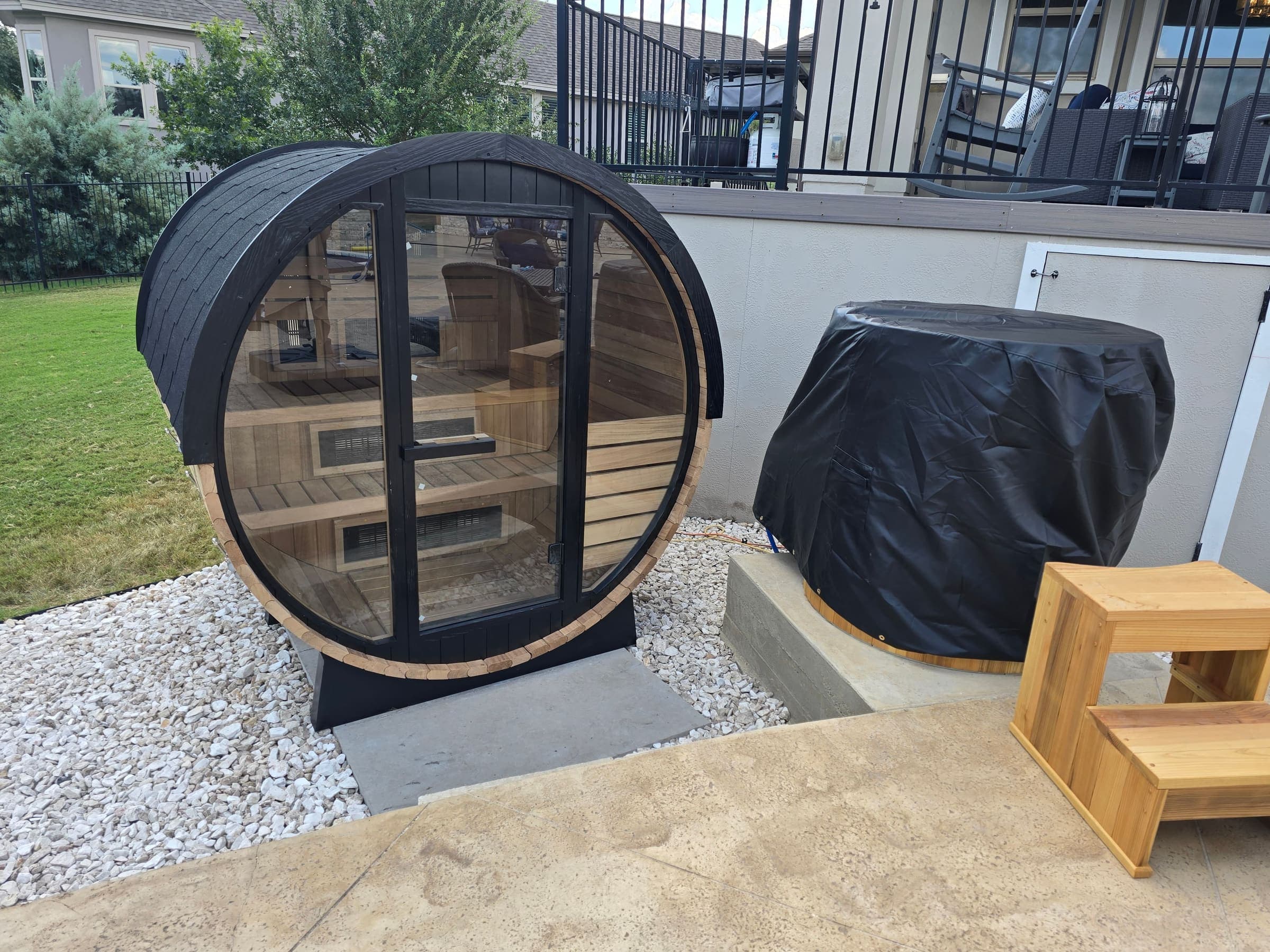 Backyard barrel sauna installation with stone landscaping — Austin, TX